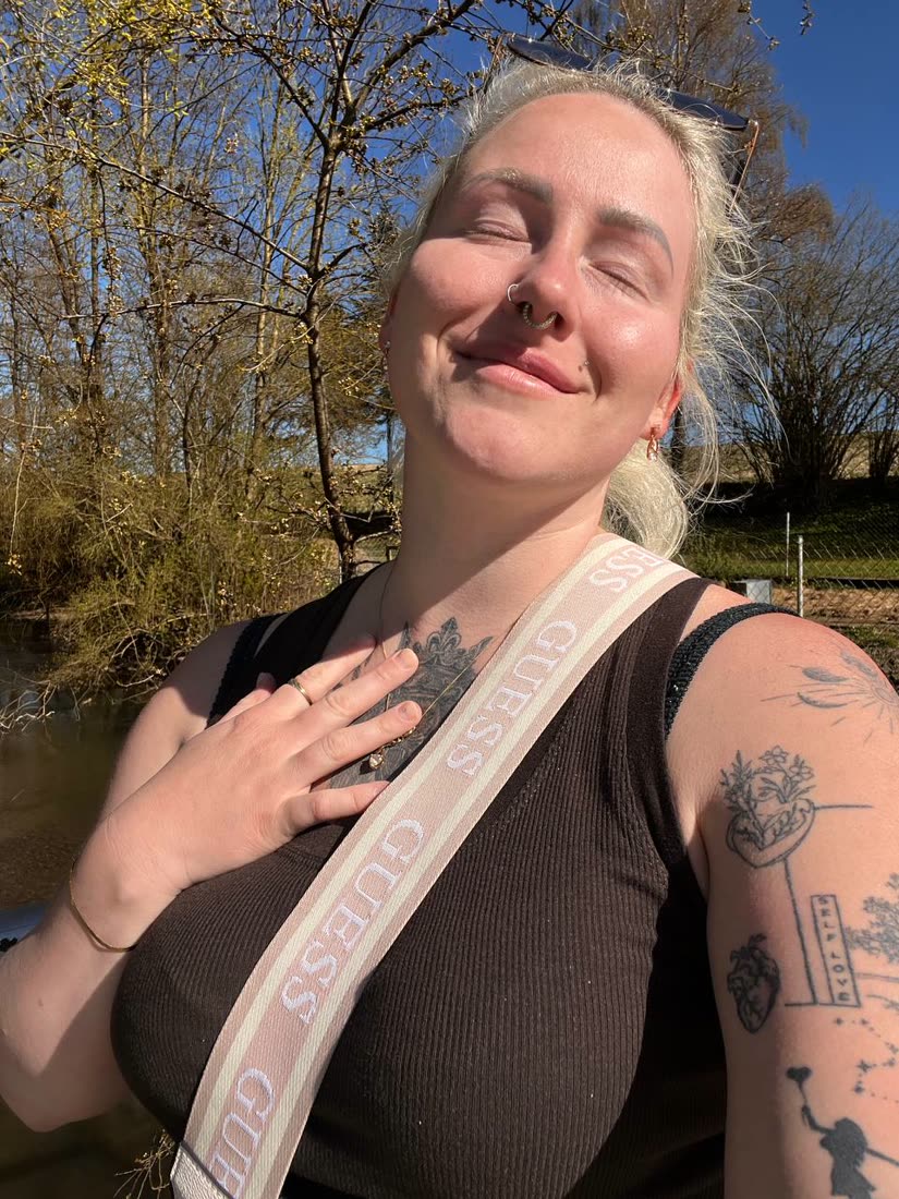 Jessica mit der Hand auf dem Herzen, Augen geschlossen, im Sonnenlicht